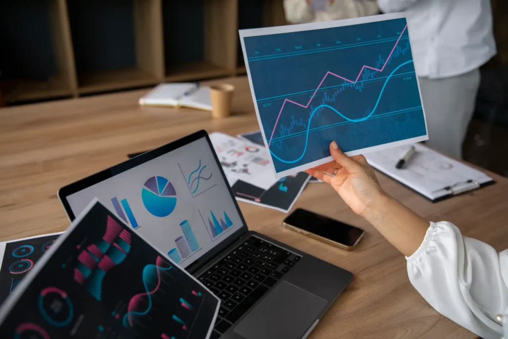 Imagem mostrando uma mesa com gráficos e dados em dispositivos eletrônicos, representando a validação de Páginas AMP no Search Console.