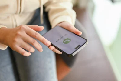 Pessoa usando smartphone para receber chamadas, com foco na importância de mensagens gratuitas no WhatsApp para negócios e como usar o novo modelo a favor do seu negócio.