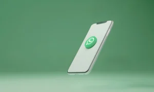 Telefone celular exibindo o logo do WhatsApp, simbolizando o sistema de nomes de usuário na plataforma de mensagens com mudança de número para nome de usuário.